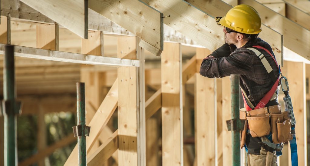 construction worker and newly built wooden roof frame 1024x548 1